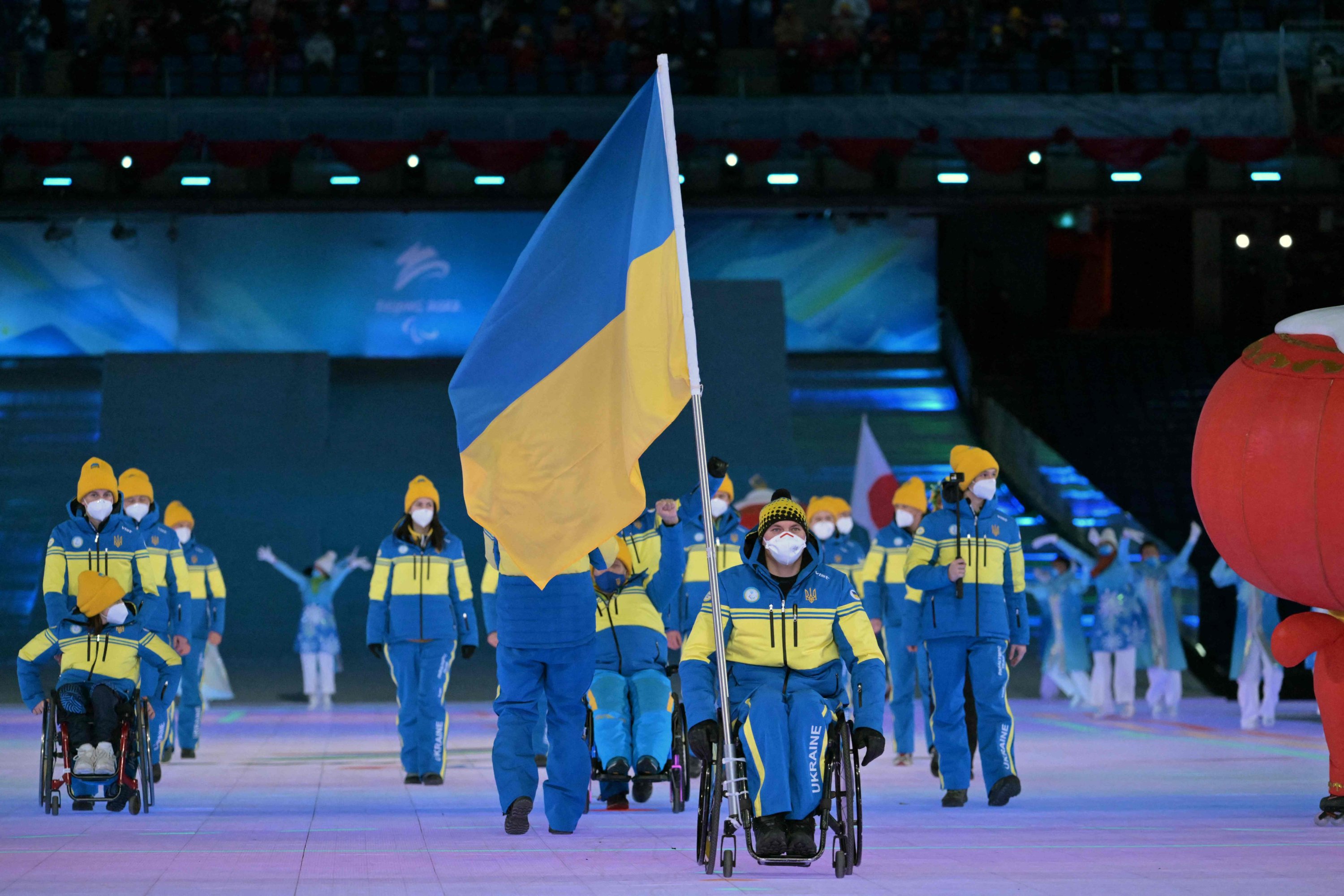 Ukraynalı bayrak taşıyıcı Maksym Yarovyi, Pekin 2022 Kış Paralimpik Oyunları açılış töreni sırasında atletlerin geçit töreninde Ukrayna heyetine liderlik ediyor,
