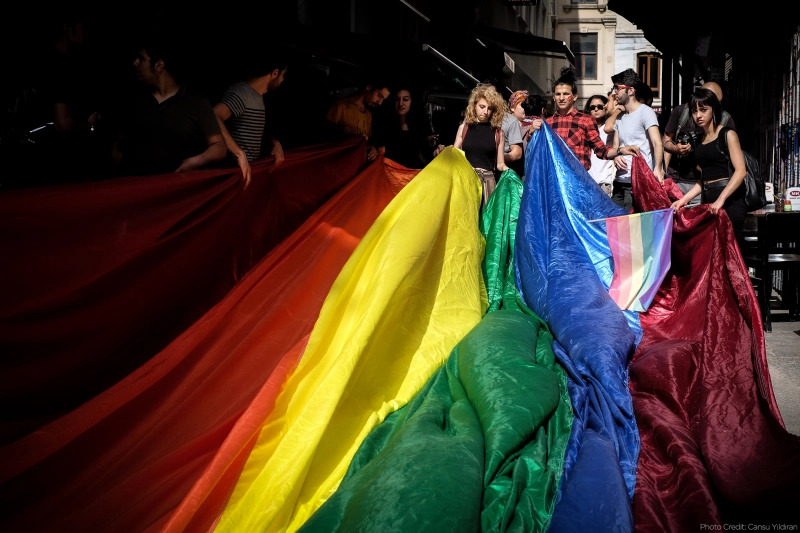 Aktivistler LGBTİ+ bayrağını kaldırıyor.