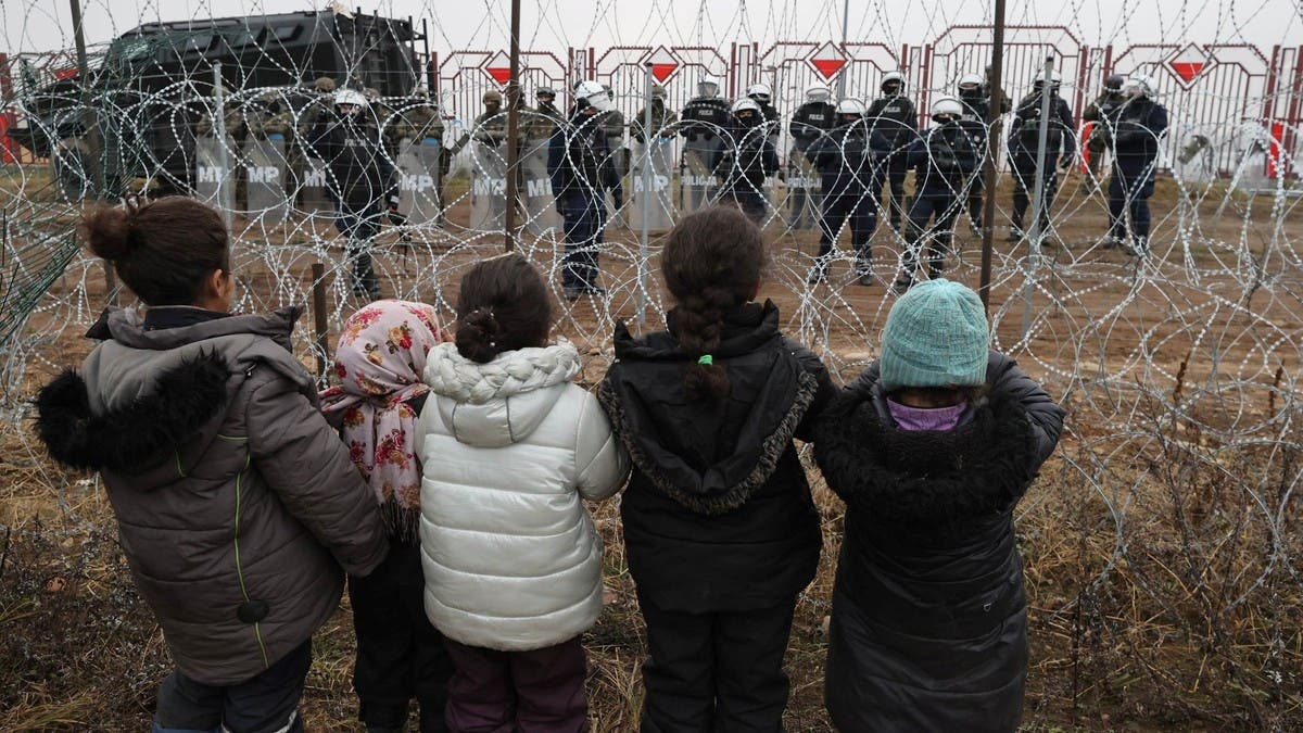 Belarus-Polonya sınırındaki Bruzgi-Kuznica sınır kapısı yakınlarındaki Polonya kampına geçmeyi hedefleyen göçmenler. (AFP)