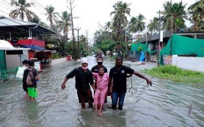 Asya'da su basmış bir köyde yaralıları taşıyan sağlık görevlileri