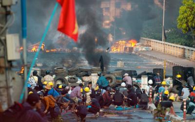 Yangon, Myanmar'daki Bayint Naung Köprüsü'nde güvenlik güçleriyle çatışan darbe karşıtı protestocular bir barikatta siper alıyorlar.