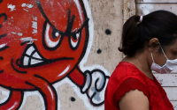 virüs grafitisi yoldan geçen kadını takip ediyor