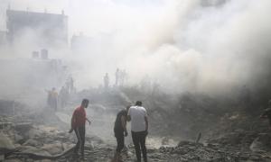 Filistinliler 12 Ekim 2023'te Gazze Şeridi'nin güneyindeki Refah mülteci kampında İsrail'in düzenlediği hava saldırısının ardından hayatta kalanları arıyor.