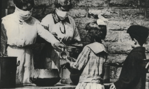 İspanyol Gribi,1918-1919, Cincinnati sokak mutfağı. Gönüllüler maskeler ile çocuklara yemek servis ediyor. / Courtesy of Spokesman-Review Archives