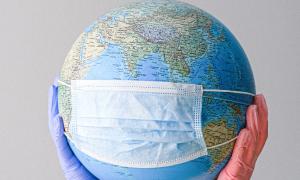Dünya küresine takılmış tıbbı maske