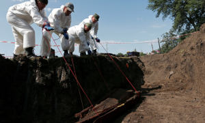 Gönüllüler, Donetsk'teki isyancıların kontrolündeki Snizhne köyündeki bir mezarlıkta toplu mezardan bir tabut kaldırdı